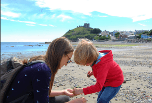 parent teaching child on beach
